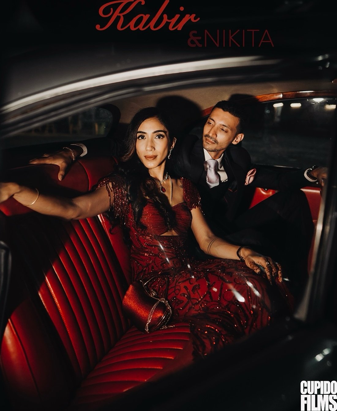A couple seated together in a vintage car